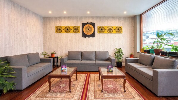 A living room with two grey sofas, a coffee table, and a patterned rug.