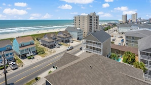 A coastal town with beachfront properties, a main road, and a beach in the background.