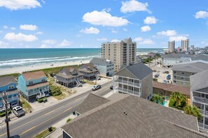 A coastal town with beachfront properties, a main road, and a beach in the background.