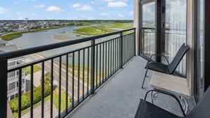 A balcony with a view of a river and surrounding landscape.