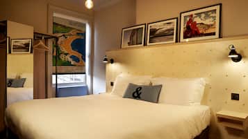 Una habitación de hotel con una cama grande, cabecera de madera y estante en la pared.