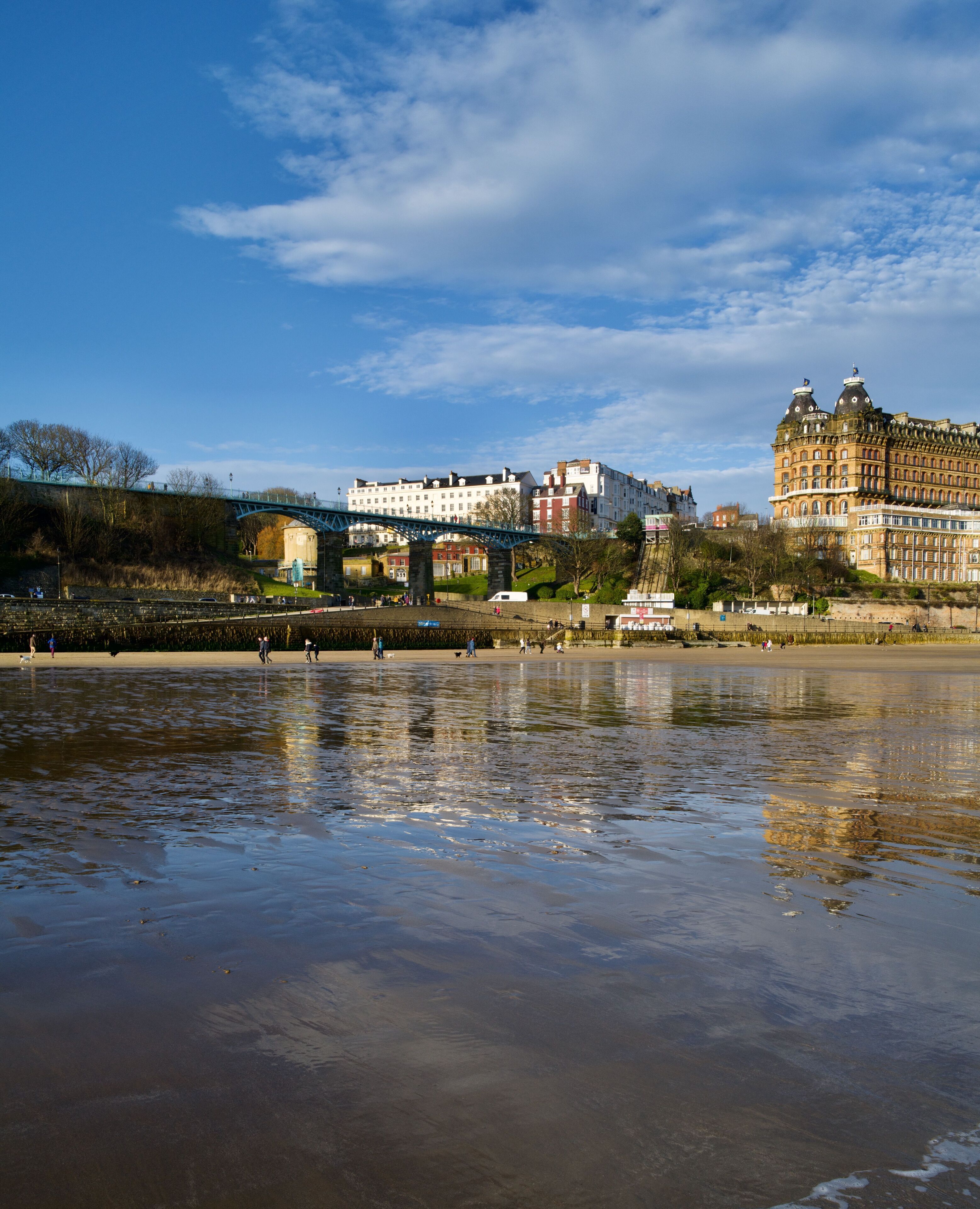 A riverside view with a bridge, historic buildings, and a waterfront promenade.