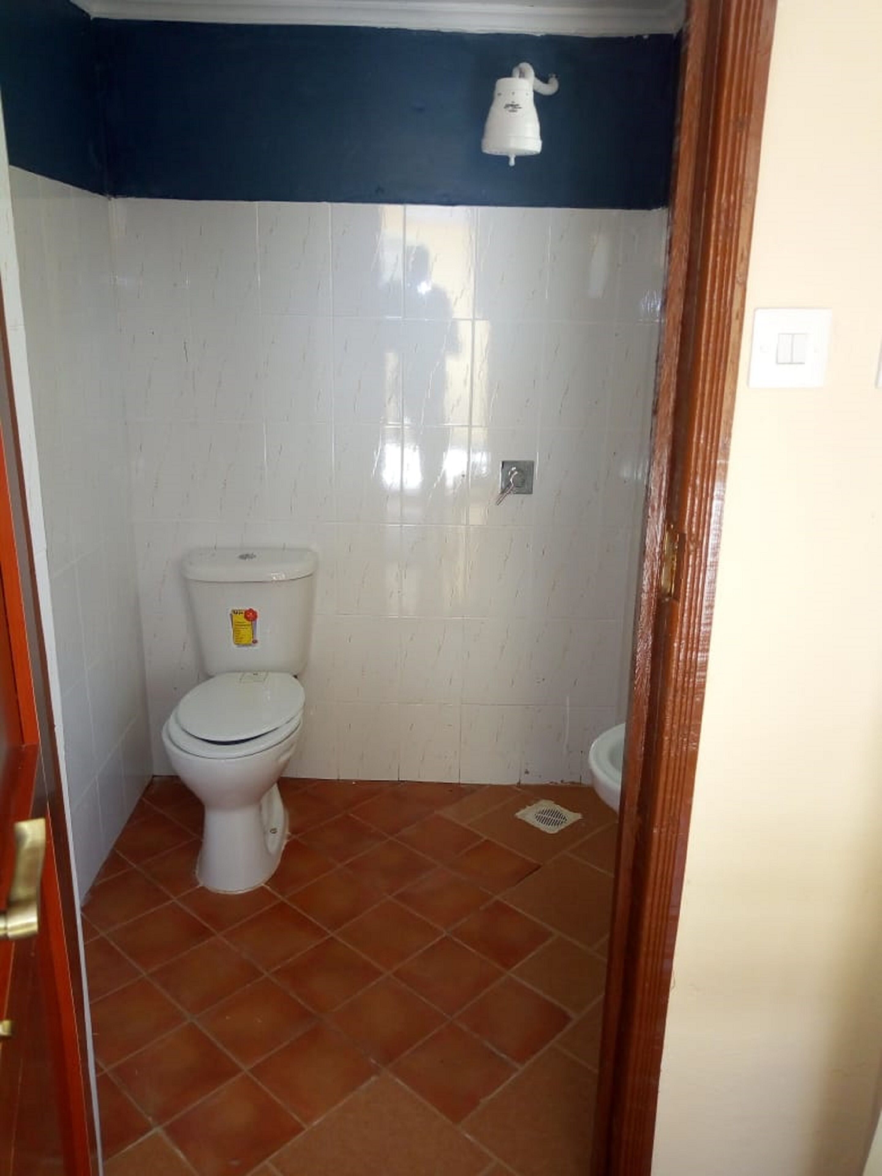 A small bathroom with a toilet, a shower, and a sink.