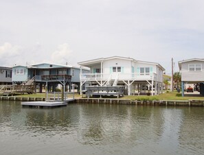 A waterfront property with multiple houses connected by walkways over water.
