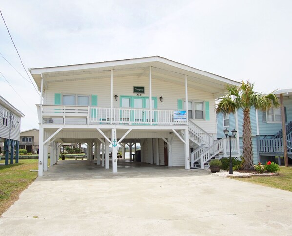 A two-story building with a covered entrance and a balcony.