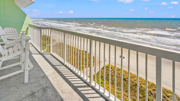 A balcony with a view of the ocean, a pier, and a green wall. - Premier resort offering deluxe oceanfront condos in the heart of family-friendly North Myrtle Beach (North Myrtle Beach)