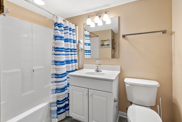 A bathroom with a bathtub, a sink, a toilet, and a shower curtain. - Premier resort offering deluxe oceanfront condos in the heart of family-friendly North Myrtle Beach (North Myrtle Beach)