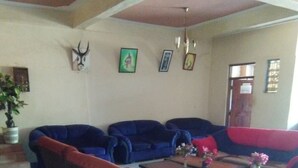 Ein Wohnzimmer mit blauen und roten Sofas, einem Couchtisch und einem gemusterten Teppich.