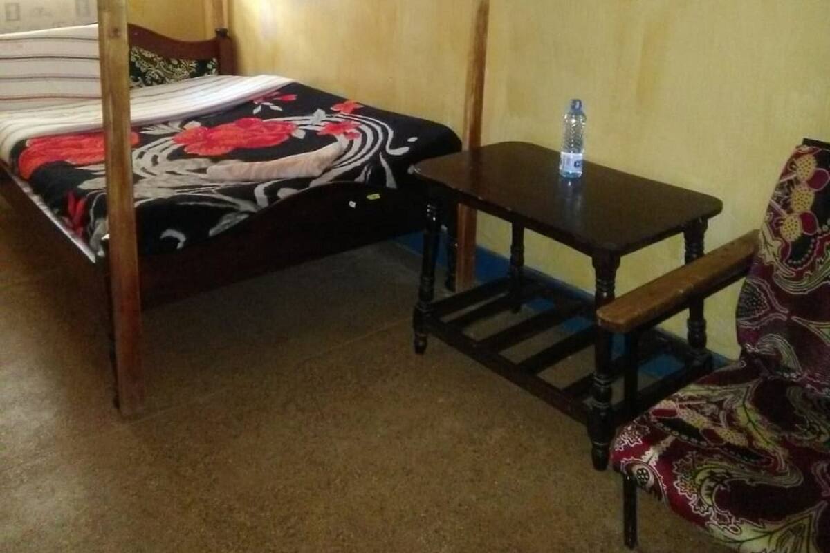 Ein Zimmer mit einem Bett, einem Tisch und einem Stuhl.