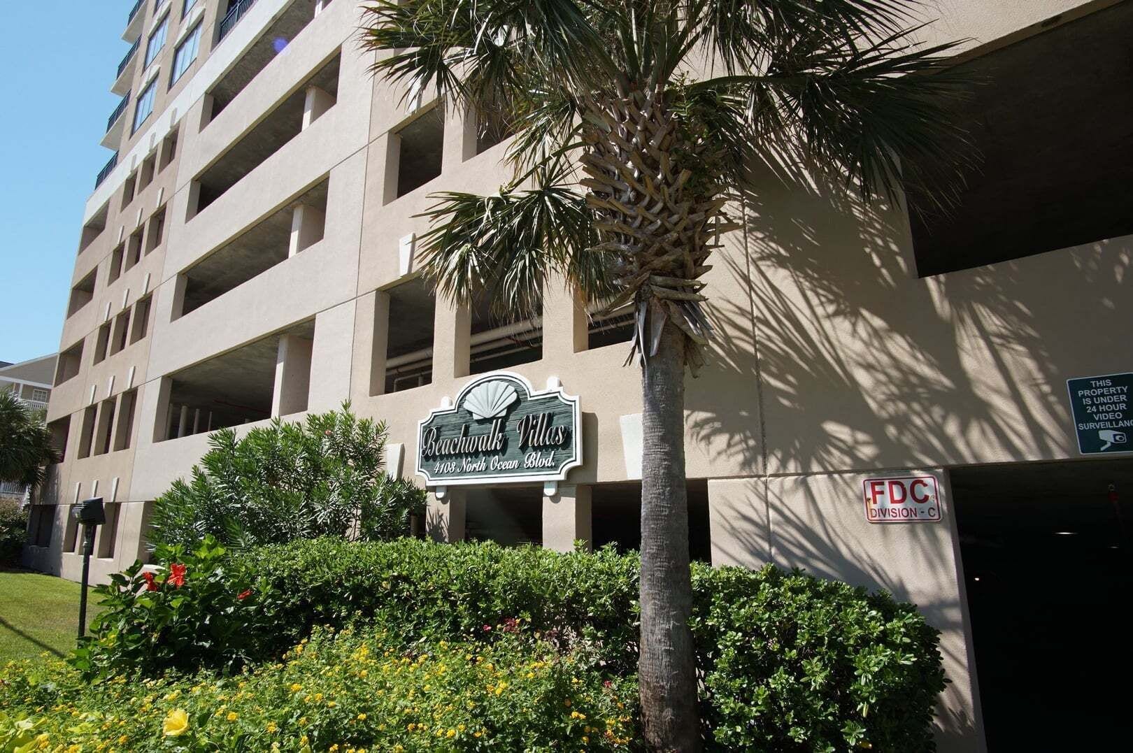 A multi-story building with a sign for Beachwalk Villas at 4108 North Ocean Blvd.