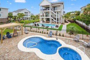 A residential area with a swimming pool, lounge chairs, and a covered patio area. - Spacious, family-friendly oasis in North Myrtle Beach (North Myrtle Beach)