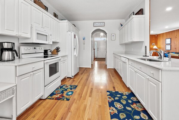 Enjoy cooking in this well-equipped kitchen with a microwave, oven, refrigerator, coffee maker, and knife block.