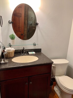 Bathroom features a sink, toilet, and cabinet.