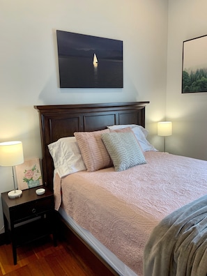Relax in a serene retreat with a large bed, bedside tables, and a soothing sailboat painting.