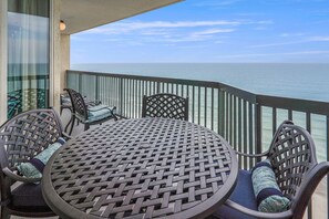 Enjoy a serene view from this balcony with a table and chairs, perfect for taking in the surroundings.