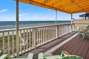 A wooden deck with a railing overlooking a beach. - Oceanfront duplex steps from beach w/shared pool, game room, kids' pool, grill (North Myrtle Beach)