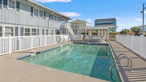 A swimming pool with a white fence, a lifeguard chair, and a lifeguard stand. - Beautiful décor & large private pool! Spacious family home includes decks & huge yard in N. Myrtle. (North Myrtle Beach)
