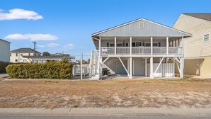 A two-story house with a balcony, a covered front porch, and a garage. - Beautiful décor & large private pool! Spacious family home includes decks & huge yard in N. Myrtle. (North Myrtle Beach)