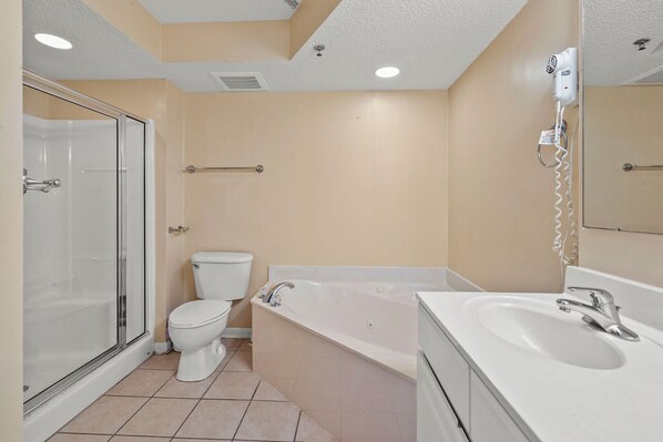 A bathroom with a toilet, bathtub, and sink. - Your Ultimate Oceanfront Escape! (North Myrtle Beach)