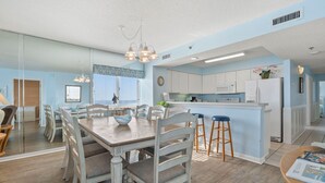 A modern kitchen with white cabinets, a central island, and bar stools. - Your Ultimate Oceanfront Escape! (North Myrtle Beach)