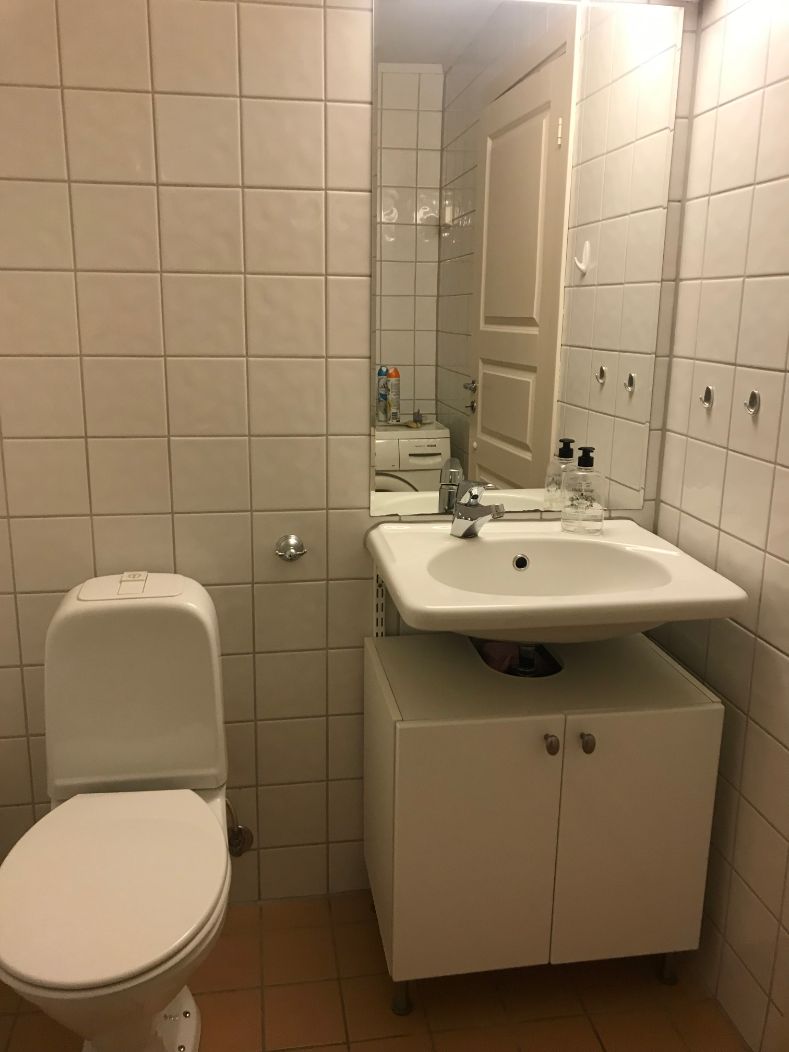 Une salle de bain avec des toilettes, un lavabo et un meuble de rangement.