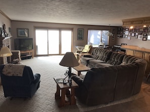 Una sala de estar con sofá, sillones, una mesa de centro, televisor y chimenea.