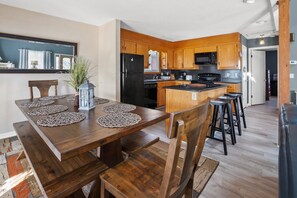 A modern kitchen with wooden cabinets, a black refrigerator, and a microwave. - Quiet waterfront home, sun decks, lots of privacy - North Myrtle Beach (North Myrtle Beach)