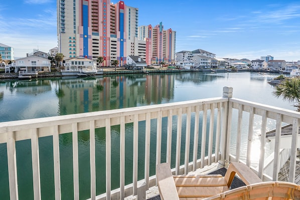 A waterfront view with a wooden deck and a row of colorful buildings in the background. - Quiet waterfront home, sun decks, lots of privacy - North Myrtle Beach (North Myrtle Beach)