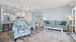 Een moderne woonkamer met een bank, een salontafel en een eetgedeelte met stoelen en een tafel.