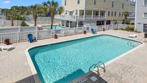 A rectangular swimming pool with a white deck and a white fence surrounding it. There are lounge chairs and potted plants around the pool. - Boulevard condo, steps from the beach, w/pool & sundeck, intimate setting for couples & families (North Myrtle Beach)