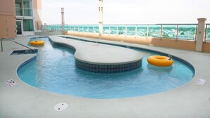En pool med en böjd design, en livräddarstation och utsikt över havet.