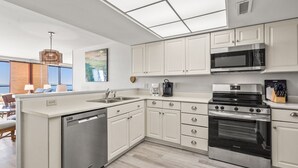 A modern kitchen with white cabinetry, stainless steel appliances, and a dishwasher.