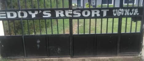 A black metal gate with the text "EDDY'S RESORT UGANJA" on it.