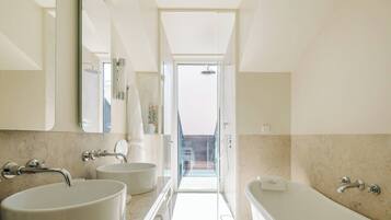 Een moderne badkamer met twee wastafels, een badkuip en een douche.
