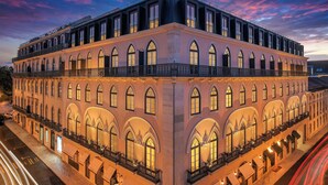 A large, multi-story building with arched windows and balconies, likely a hotel or public building. - The Ivens, Autograph Collection (Lisbon)
