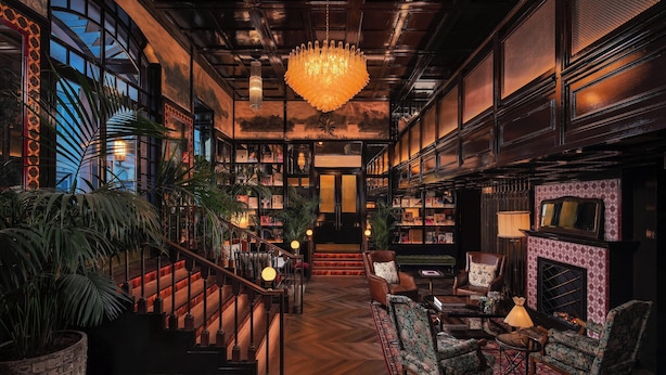 A spacious lobby with a grand staircase, a large chandelier, and a fireplace. - The Ivens, Autograph Collection (Lisbon)