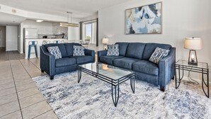 Ein modernes Wohnzimmer mit zwei Sofas, einem Couchtisch und einem Teppich.