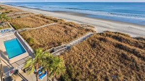 Un resort sulla spiaggia con piscina, accesso diretto alla spiaggia e vista sull'oceano.