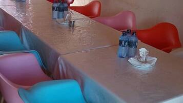 A conference room with a long table, colorful chairs, and water bottles on the table.