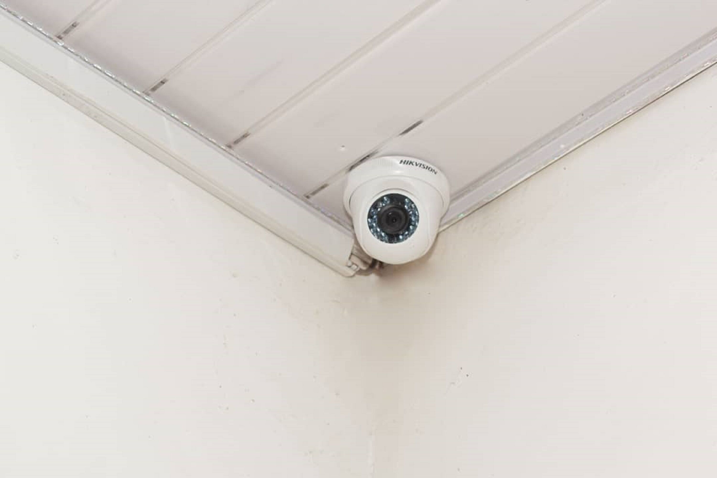 A security camera mounted on a ceiling corner.