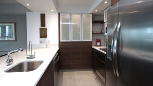 Una cocina moderna con electrodomésticos de acero inoxidable, un lavamanos doble y un horno empotrado.