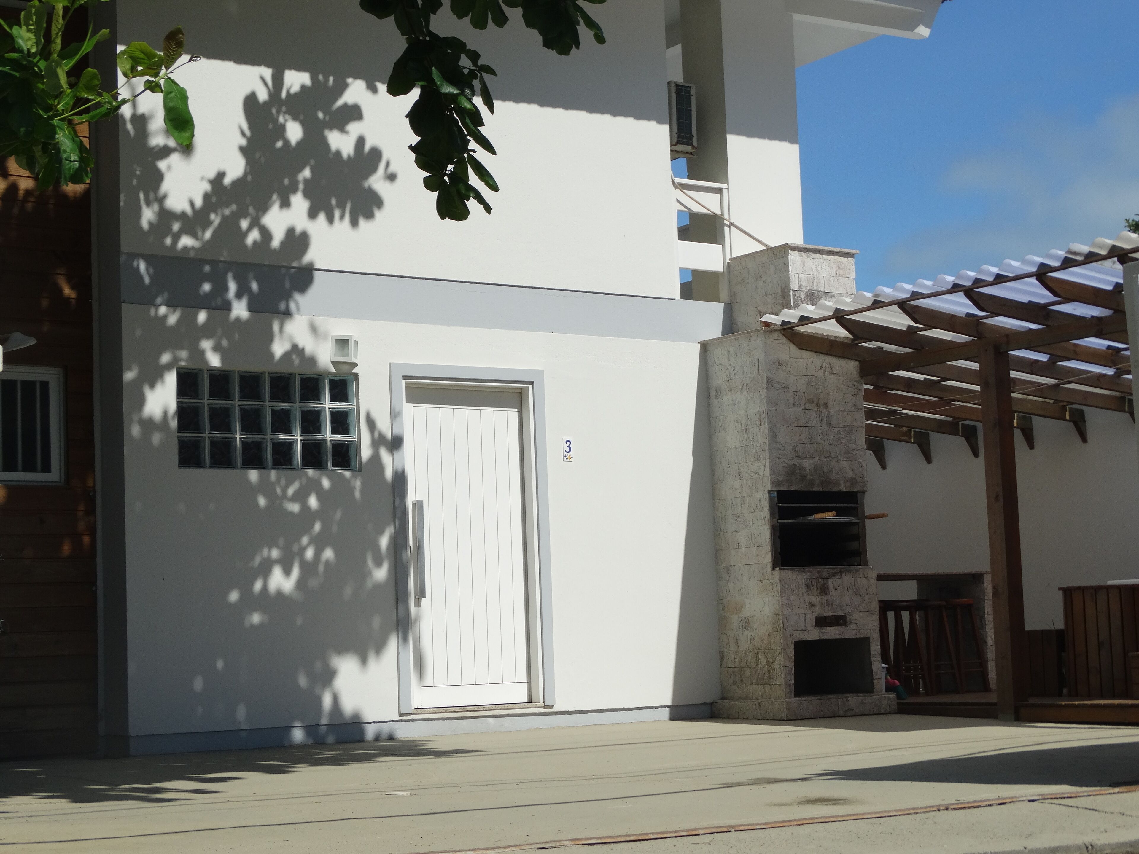 A modern building with a white exterior, a door, and a window.