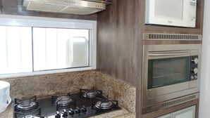Een keuken met een gasfornuis, een magnetron en een oven.