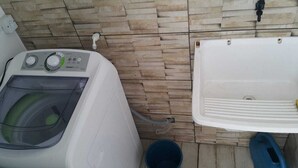 Un'area lavanderia con lavatrice e lavandino.