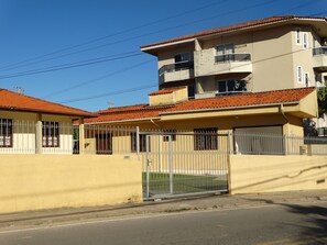Ein Wohngebäude mit gelber Fassade, rotem Ziegeldach und einem verschlossenen Eingang.
