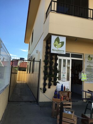 A storefront with a sign reading "Novaterra Paisagismo" and a display of potted plants. - Apartment 1D, 50m From the Sea - 65 (Florianópolis)