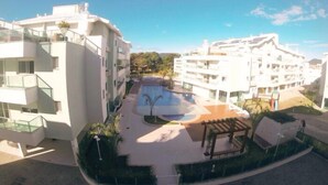 A modern apartment complex with a central swimming pool, multiple balconies, and a well-maintained garden area. - 2 Bedroom Apartment - 201 (Florianópolis)