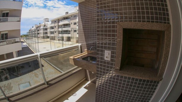 Ein Balkon mit Glasgeländer mit Blick auf ein Wohngebiet.