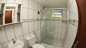 Een badkamer met een wit wastafelmeubel, toilet en douchecabine.