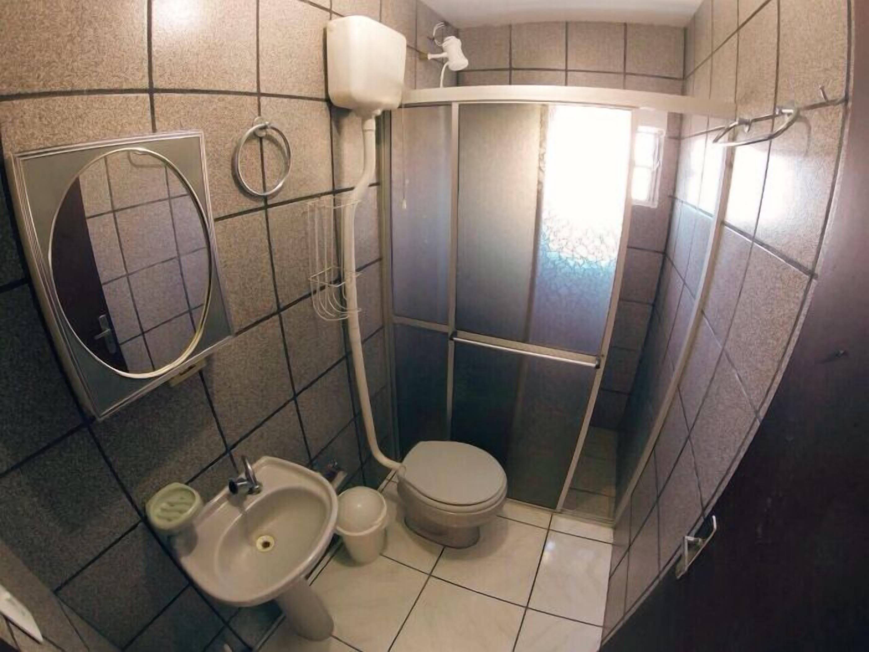 Une petite salle de bain comprenant des toilettes, un lavabo et un espace douche.